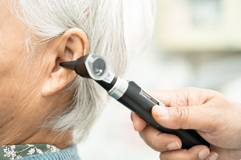 Audiologist or ENT doctor use otoscope checking ear of asian senior woman patient treating hearing loss problem.