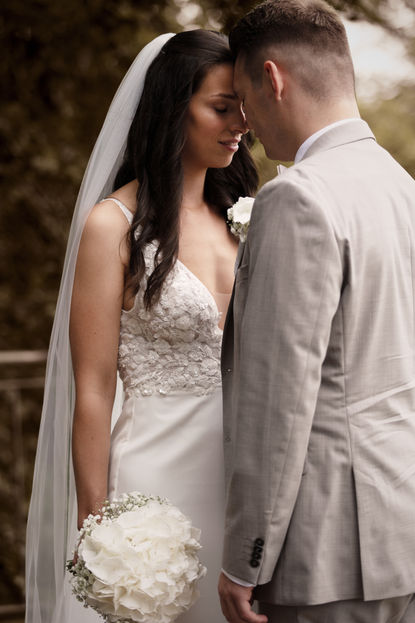 Vertrauter Moment zwischen dem Brautpaar. Brautpaar steht Stirn an Stirn zueinander