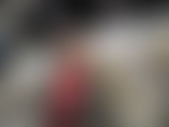 Woman smiling inside a modern spacecraft cockpit with complex control panels. She wears glasses and a gray jacket. High-tech setting.