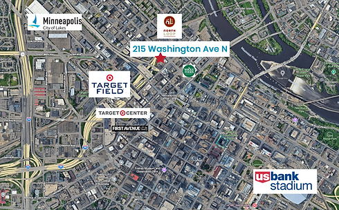 An aerial satellite map of downtown Minneapolis centered on 215 Washington Ave N in the North Loop neighborhood. Major landmarks are labeled with logos, including Target Field, Target Center, First Avenue, Whole Foods Market, and U.S. Bank Stadium. The Mississippi River and Nicollet Island are visible to the northeast.
