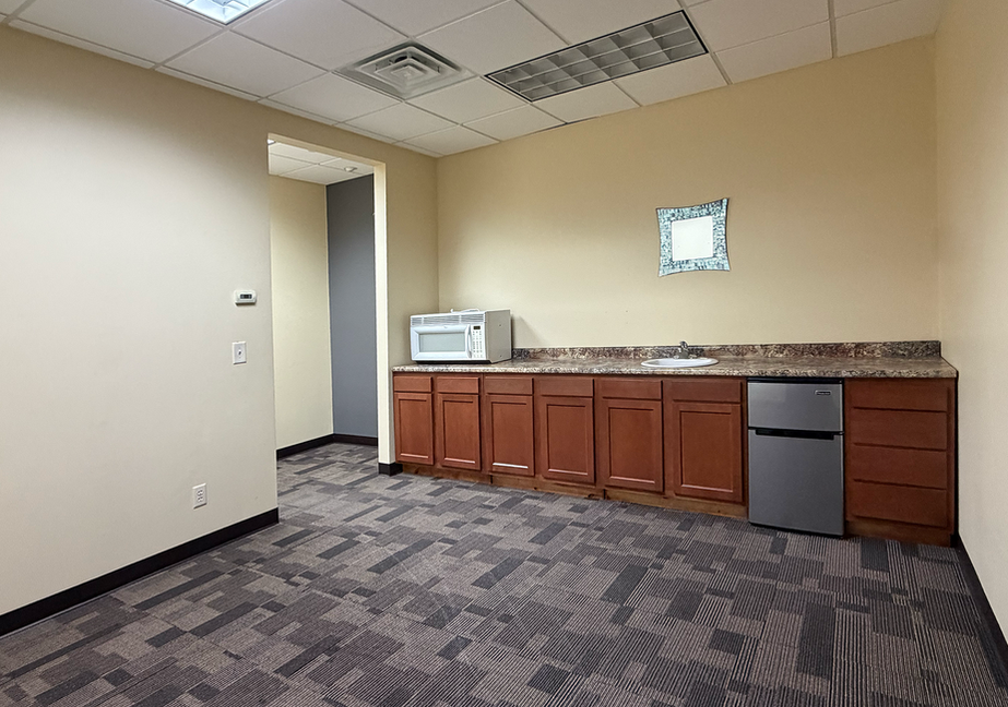 Office break room with kitchenette and mini fridge.