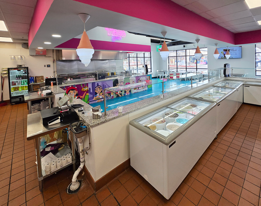 Modern ice cream shop interior with glass display freezers.