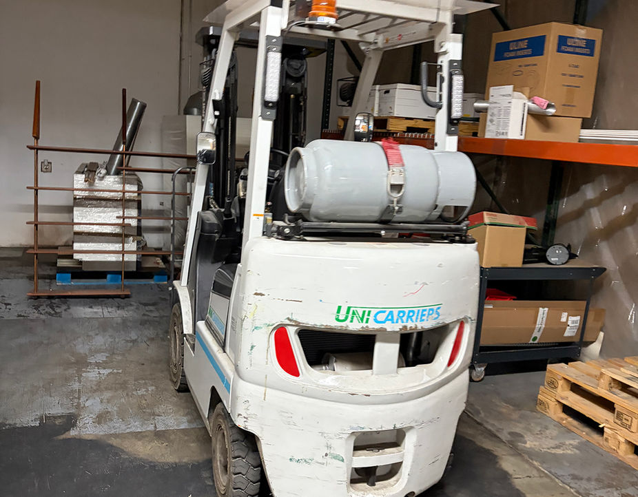 White UNI CARRIERS forklift with propane tank.