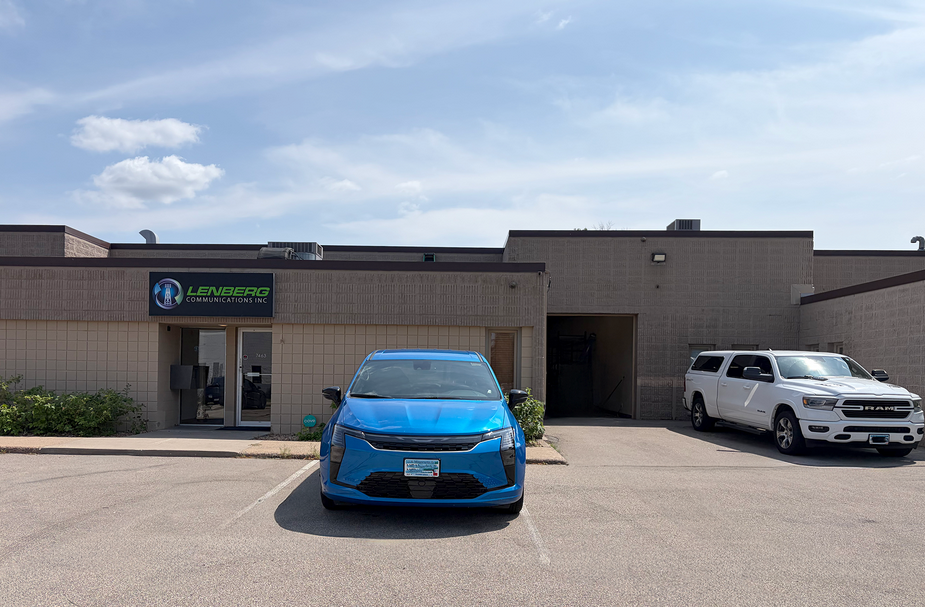 Exterior industrial condo building with blue car parked in front