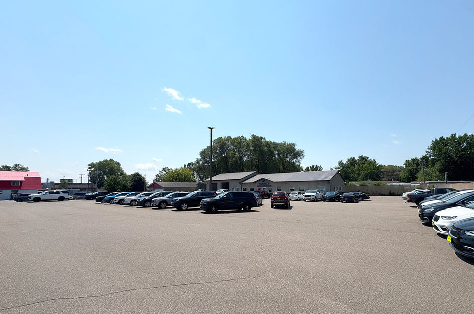 Morrie's vehicle inventory lot under a clear blue sky.