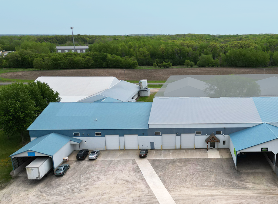 Commercial building in Waite Park with two drive-ins signs, pedestrian portico and two covered docks on  the right. Another industrial space on the left with covered docks and two drive-ins.