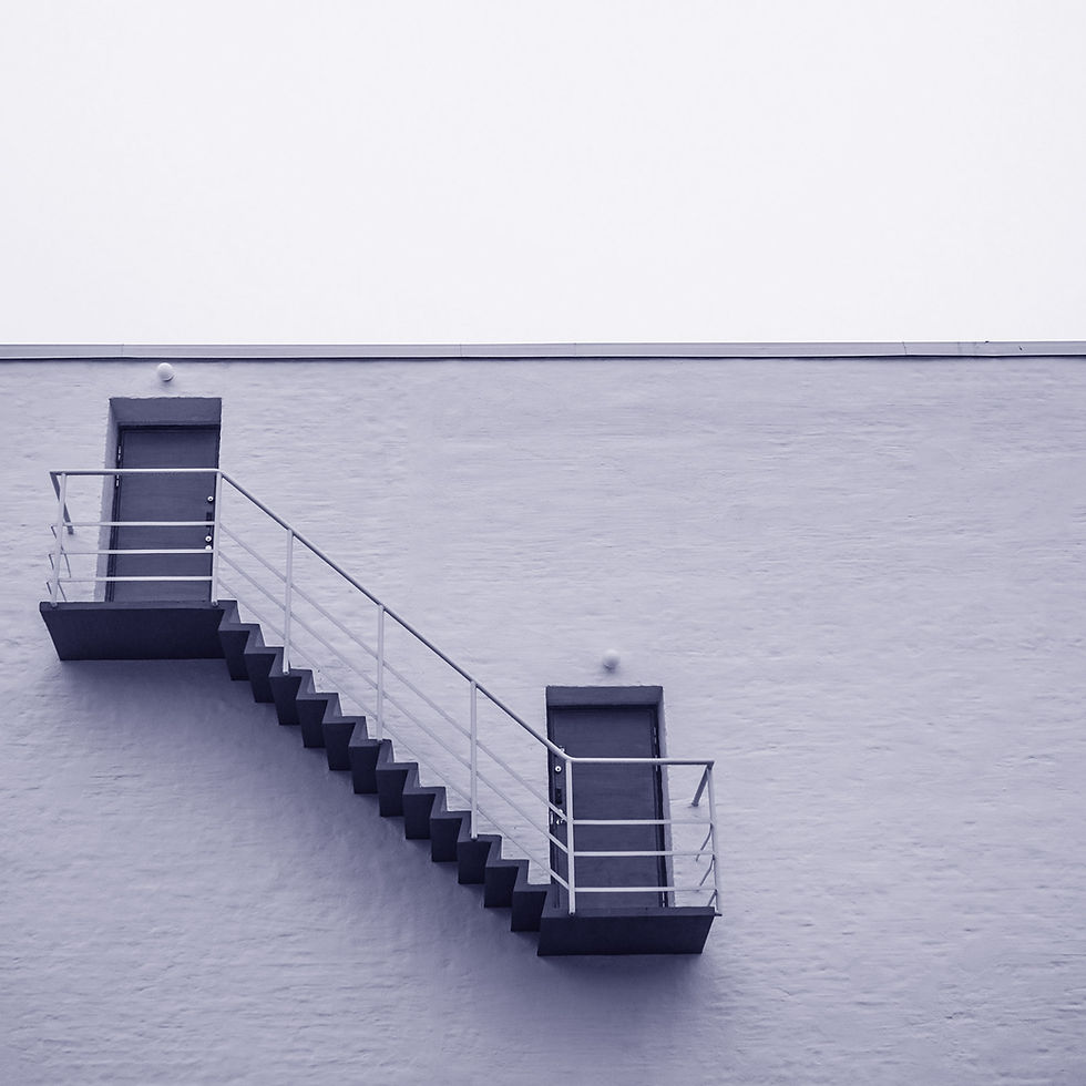Stairs leading for one door to another at the top of a commercial building.