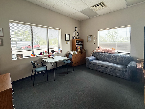 Climb Theatre office with sofa, table, and windows.