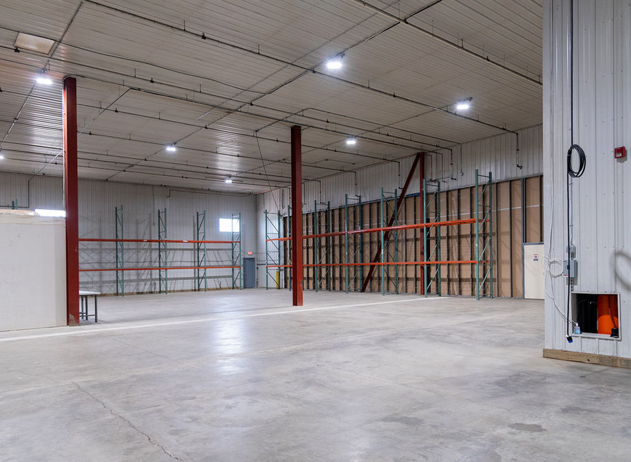 Large clean warehouse space with office and shelving. 