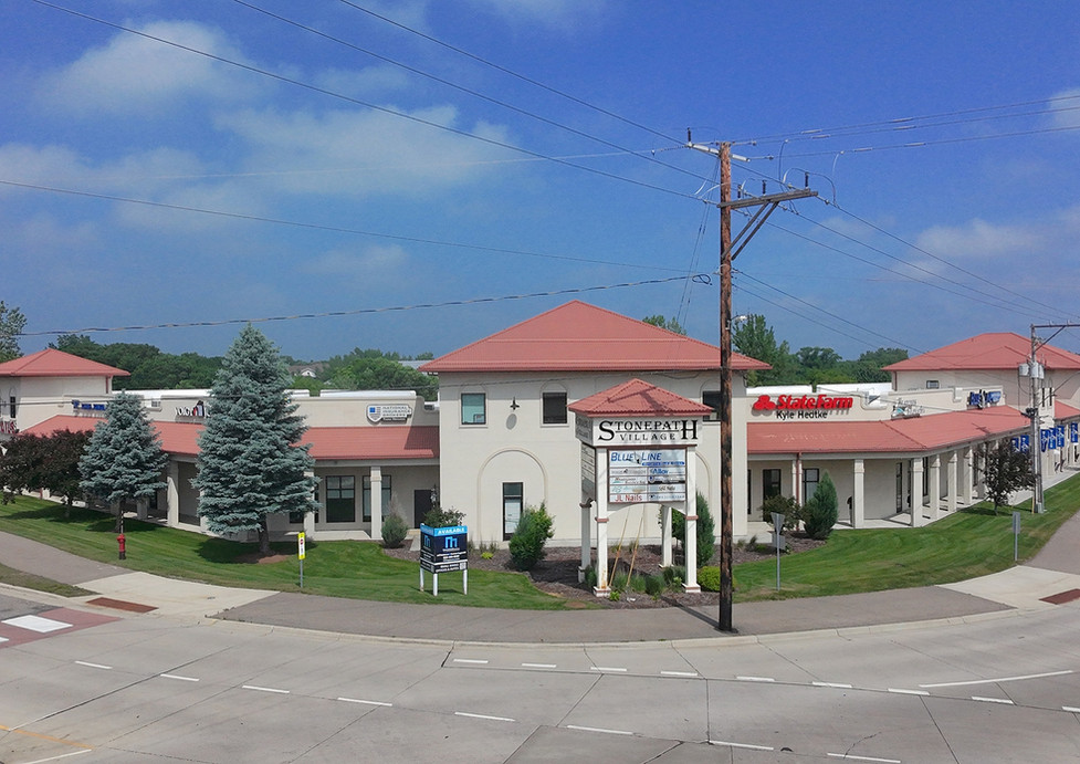 Small shopping plaza with red roofs and Stone Path sign.