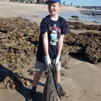 Ethan Fourie on a beach clean-up, picking up litter