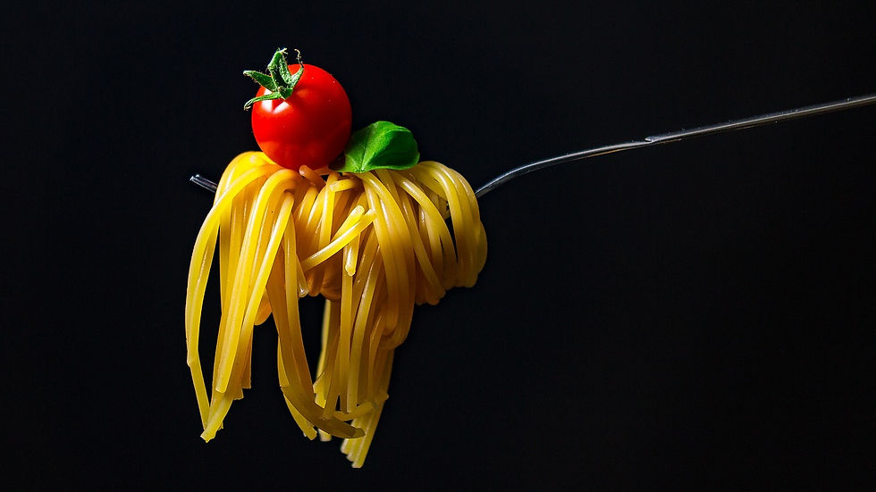 siyah arka plan önünde kaşığa takılmış bir spagetti makarna ve üstünde küçük domotes.