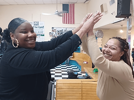 Boulder Bowl, Bowling Alley in Boulder City, Nevada, USA - PHOTO TWO WOMEN HIGH-FIVING IN BOULDER BOWL, WITH AMERICAN FLAG IN THE BACKGROUND