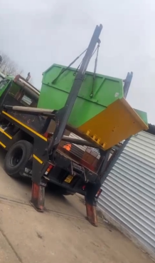Green skip being delivered