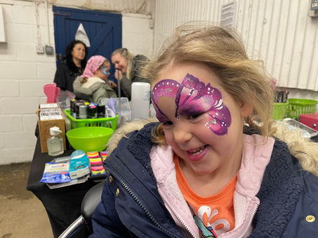 Girl smiling with pink face paint on her face