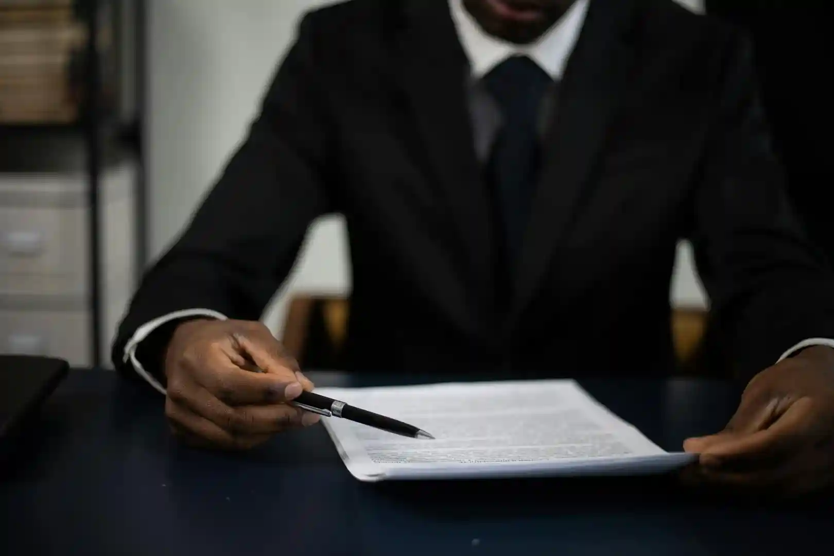 person pointing to document with pen - Owner Financing Homes 