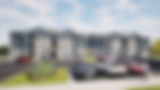 Modern three-story apartment complex with parking lot.
