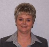 Picture of a lady with blond hair wearing  a business suite
