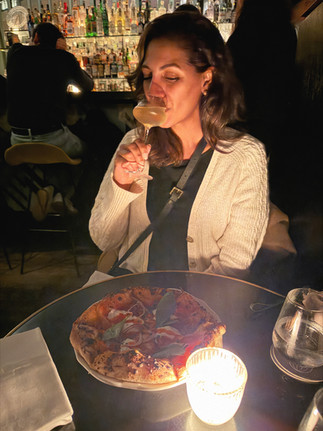 Woman drinking a cocktail in a candle lit table. Danico bar best bars in Paris.