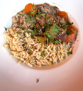 food platter with rice, beef stew, potatoes, carrots, and parsley. 