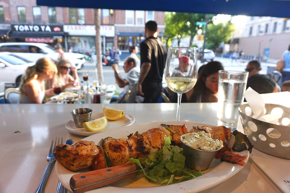 Bar dining facing the street at Taverna Kyclades in Astoria, Queens, New York City. Chicken Souvlaki Platter (Chicken Kabab).