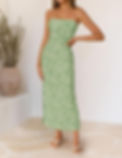 Woman in a green strapless floral dress and sandals stands indoors beside a potted plant, posing against a light wall.las vegas summer dresses.