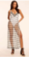 Confident woman poses in a patterned white-and-brown maxi dress and black wedge sandals, the perfect outfit for a pool party in Vegas.