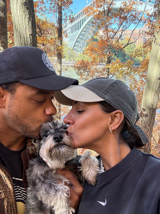 Couple kissing their miniature schnauzer dog.