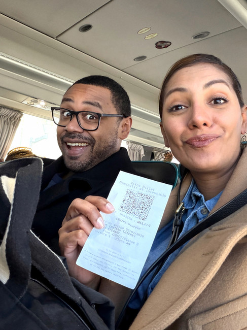 couple holding up a ticket on a bus from a Paris day trip. Paris tour.