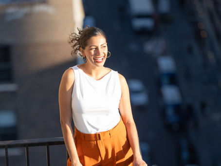 Woman overlooking New York City from a rooftop. Travel Guide to NYC to avoid the crowds.