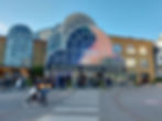 Inner architecture of the Business Design Centre in Islington, showing the vaulted glass ceiling and multi-level balconies within the main exhibition hall.