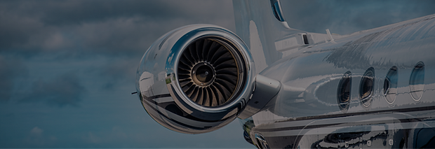 Close-up of a polished jet engine and T-tail on a modern business jet, reflecting the mood