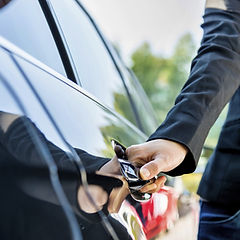 Executive car door being opened by chauffeur