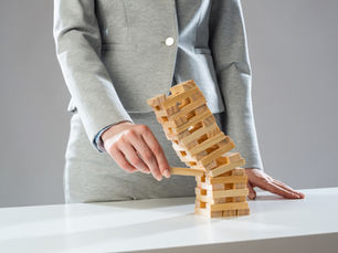 Woman knocking over a Jenga tower
