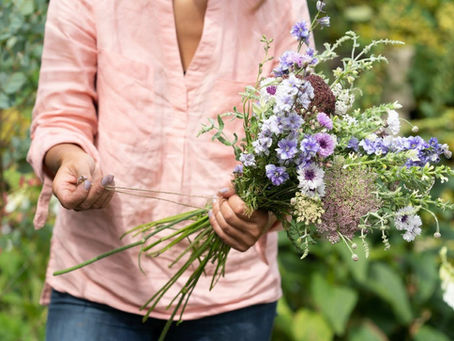 person in peach top holding flowers