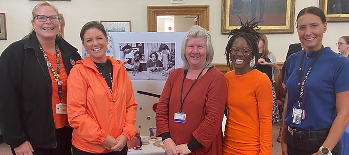 5 people smiling for a photo in a library