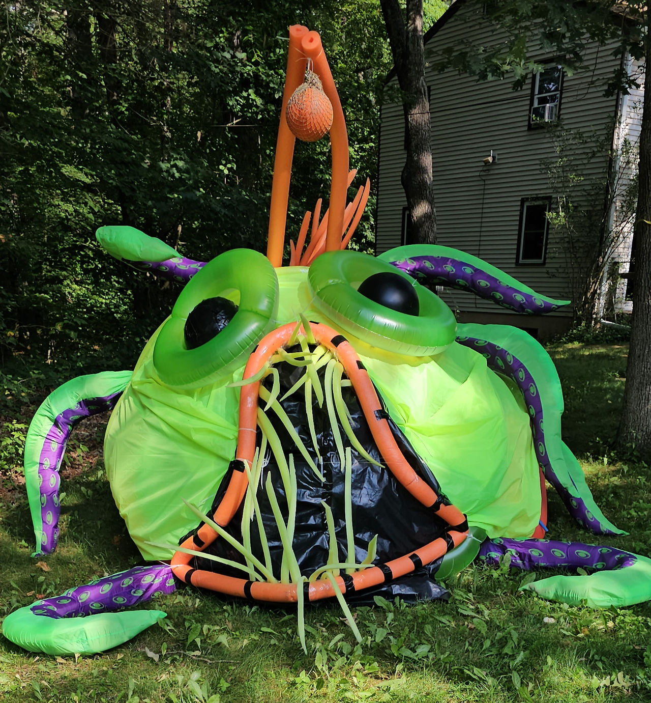 Constructed giant sea creature LARP costume looks like an angler fish with bright colors
