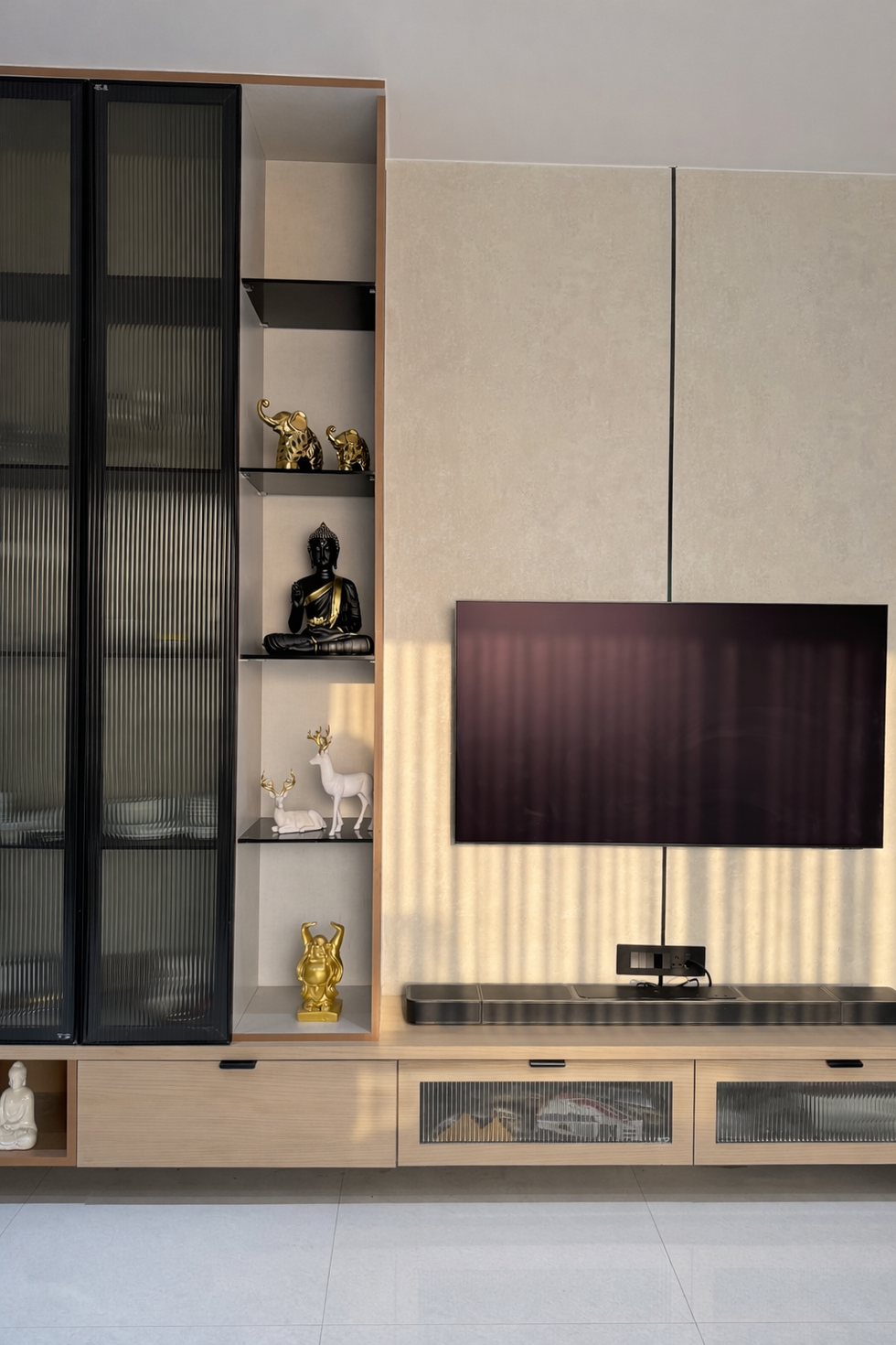 Modern TV unit and custom display wall with textured panels and integrated shelving designed by Woods and Bricks, interior designers in Lucknow