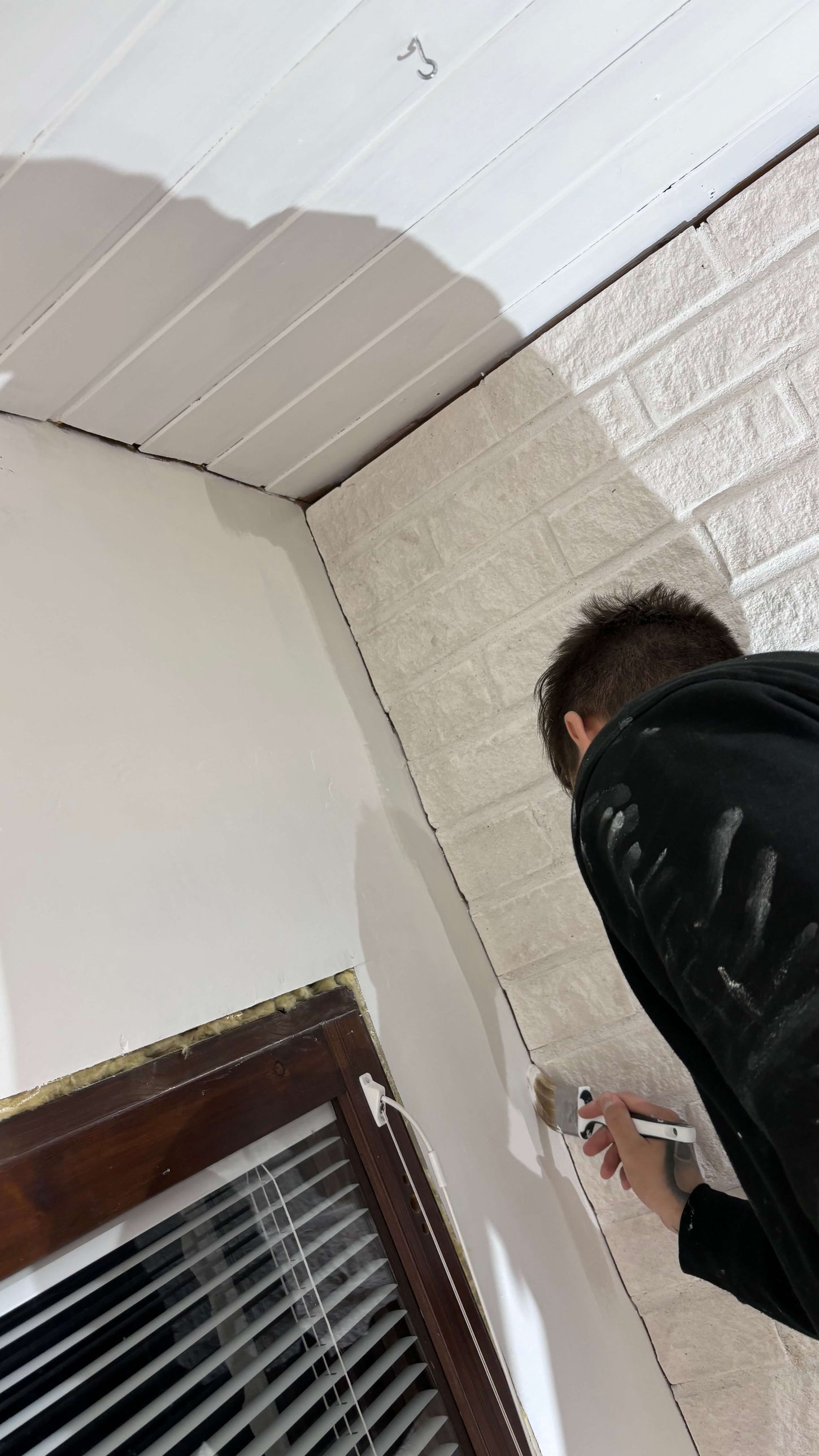 Sisämaalaus yksityiskohtien viimeistelyssä ammattimaalarin toimesta.