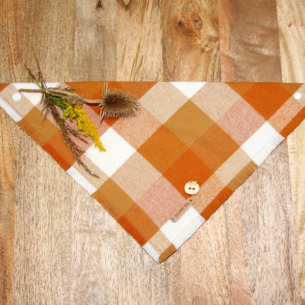 Pumpkin Spice plaid dog bandana in orange, gold and cream with wooden pumpkin charm on wood background