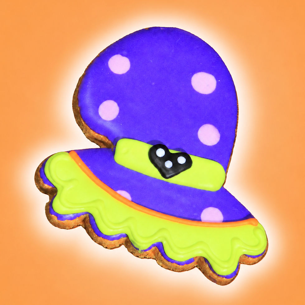 Purple witch hat Halloween dog cookie with lime green brim, pink dots and black buckle on orange background