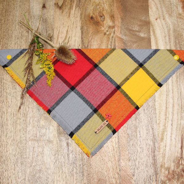 Fireside Glow plaid dog bandana in red, yellow, orange and gray with rustic frayed edge on wood background