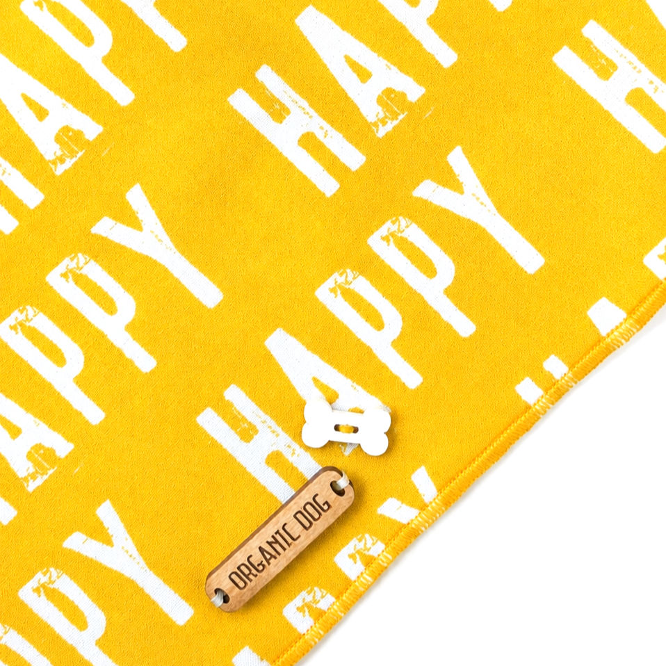 Yellow Happy dog bandana detail with white print, smooth cotton fabric, stitching, and Organic Dog tag