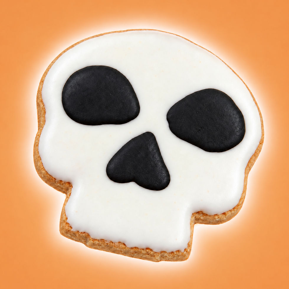 Hand-decorated skull Halloween dog cookie with white icing and black face details on warm orange background