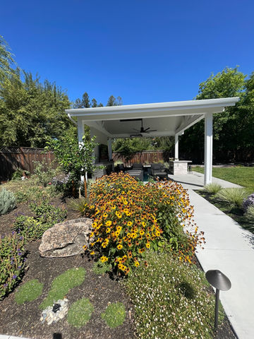 Outdoor living structure with ceiling fans and warm lighting