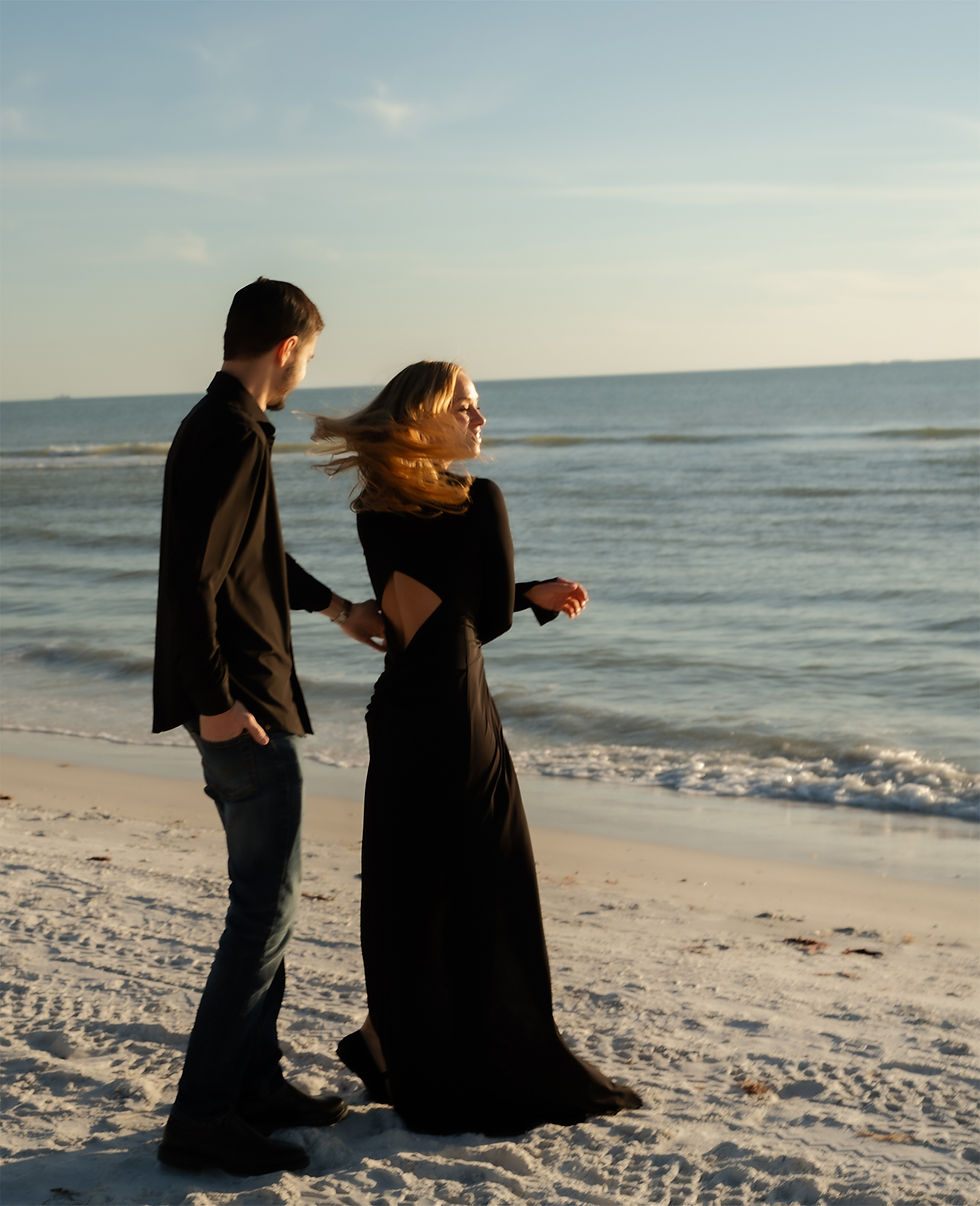 Woman spinning as her hair catches the light during a beach engagement session
