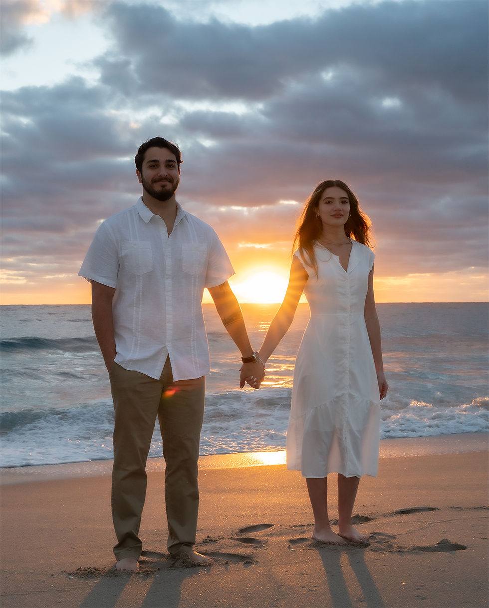 Couple holding hands on the beach during sunset, showing beach sunset wedding photos in Florida.
