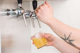 une personne servant un verre de cidre pression
