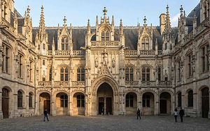 Rouen est indissociable du destin tragique de la Pucelle d'Orléans. La ville porte avec respect la mémoire de ses derniers jours en 1431.
La Place du Vieux-Marché : C'est ici, sur ce lieu chargé d'émotion, que Jeanne fut brûlée vive. Une grande croix marque l'emplacement du bûcher.
L'Église Sainte-Jeanne-d'Arc : Sur cette même place, cette église moderne à l'architecture audacieuse (évoquant un bateau viking ou un poisson) abrite de somptueux vitraux Renaissance sauvés d'une ancienne église détruite pendant la guerre. Le contraste entre l'ancien et le moderne y est saisissant de beauté.