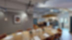 A warm, open-plan kitchen/teapoint and large dining area with a tall, exposed service ceiling.